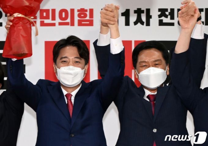 (서울=뉴스1) 오대일 기자 = 이준석 국민의힘 신임 대표가 11일 오전 서울 영등포구 국민의힘 당사에서 열린 전당대회에서 김기현 원내대표와 손을 맞잡은 채 인사하고 있다. '30대·0선'의 이 대표는 역대급 전당대회 흥행을 주도한 끝에 헌정사상 최초의 30대 보수정당 대표에 올랐다. 2021.6.11/뉴스1