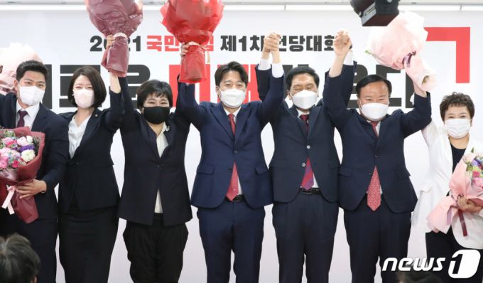 (서울=뉴스1) 오대일 기자 = 이준석 국민의힘 신임 대표가 11일 오전 서울 영등포구 국민의힘 당사에서 열린 전당대회에서 신임 최고위원들과 함께 포즈를 취하고 있다. 오른쪽부터 정미경, 김재원 최고위원, 김기현 원내대표, 이 대표, 조수진, 배현진 최고위원, 김용태 청년최고위원. '30대·0선'의 이 대표는 역대급 전당대회 흥행을 주도한 끝에 헌정사상 최초의 30대 보수정당 대표에 올랐다. 2021.6.11/뉴스1