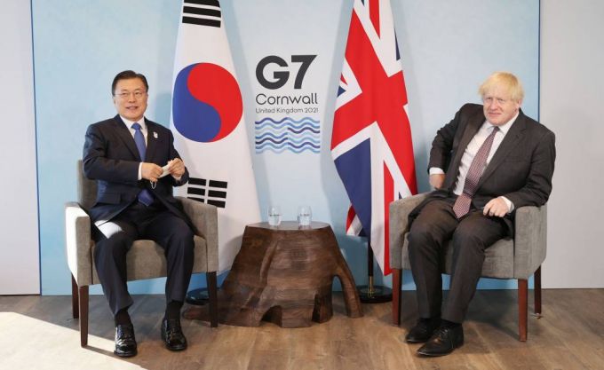 [콘월(영국)=뉴시스박영태 기자 = G7 정상회의 참석차 영국을 방문 중인 문재인 대통령이 13일(현지시간) 영국 콘월 카비스베이 양자회담장에서 보리스 존슨 영국 총리와 한-영 정상회담을 하기 위해 마스크를 벗고 있다. 2021.06.13. since1999@newsis.com