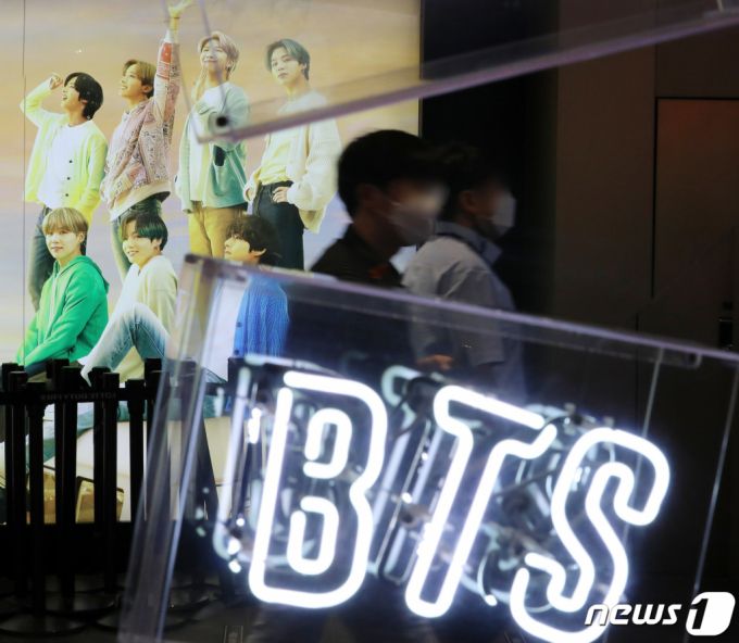 (서울=뉴스1) 김진환 기자 = 29일 오후 서울 중구 롯데면세점 마련된 BTS의 광고판 앞을 시민들이 지나가고 있다.   그룹 방탄소년단(BTS)은 미국 빌보드 메인 싱글 차트 '핫 100'에서 5주 연속 1위를 차지하는 대기록을 세웠다. 미국 빌보드는 28일(현지시간) 방탄소년단이 지난달 21일 공개한 디지털 싱글 '버터'로 빌보드 최신 차트(6월26일자)에서 '핫 100' 정상에 올랐다고 발표했다.  이로써 방탄소년단은 '다이너마이트'(3회), 피처링에 참여한 '세비지 러브' 리믹스 버전(1회), 앨범 'BE'의 타이틀곡 '라이프 고스 온'(1회), 그리고 이번 '버토'(5회) 등 4개의 곡으로 통산 10번째 '핫 100' 1위에 이름을 올렸다. 빌보드에 따르면, '핫 100'에 진입하면서 곧바로 정상을 밟은 역대 54곡이다. 이 중 5주 연속 1위를 차지한 곡은 '버터'를 포함해 11곡 뿐이다. 2021.6.29/뉴스1