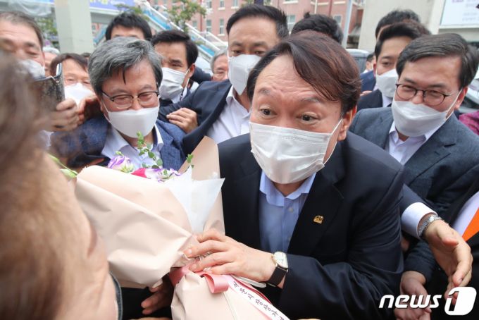 범야권 대선주자인 윤석열 전 검찰총장이 20일 낮 대구 서문시장을 찾아 환영의 꽃다발을 받고 있다. /사진=뉴스1