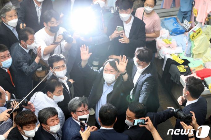 야권 대선주자인 윤석열 전 검찰총장이 20일 낮 대구 서문시장을 찾아 상가 연결통로에 환영 나온 시민들을 향해 손을 흔들어 인사하고 있다. 2021.7.20/뉴스1