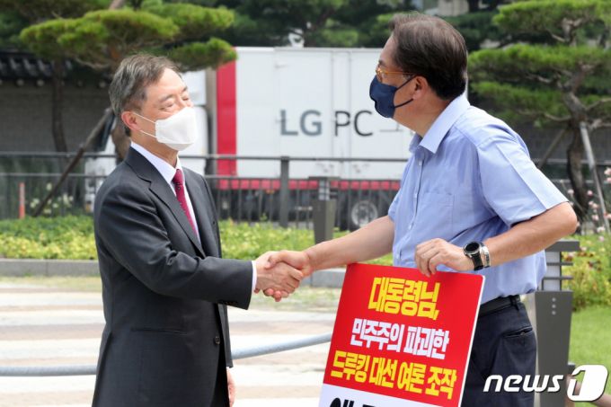 국민의힘 대권주자인 최재형 전 감사원장이 29일 오전 서울 청와대 분수대 앞에서 '드루킹 사건' 문재인 대통령의 사과를 촉구하는 1인 시위 펼치는 정진석 국민의힘 의원을 찾아 대화를 마치고 악수하고 있다. /사진=뉴스1