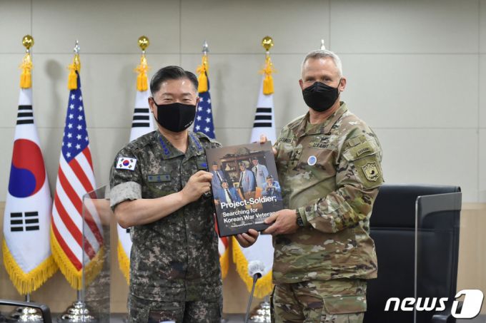 (서울=뉴스1) 포토공용 기자 = 원인철 합참의장(왼쪽)이 13일 서울 용산구 함동참모본부에서 폴 러캐머라 신임 한미연합사령관을 만나 라미 현 사진작가의 '프로젝트 솔져' 사진집을 전달하고 있다. (합참 제공) 2021.7.13/뉴스1