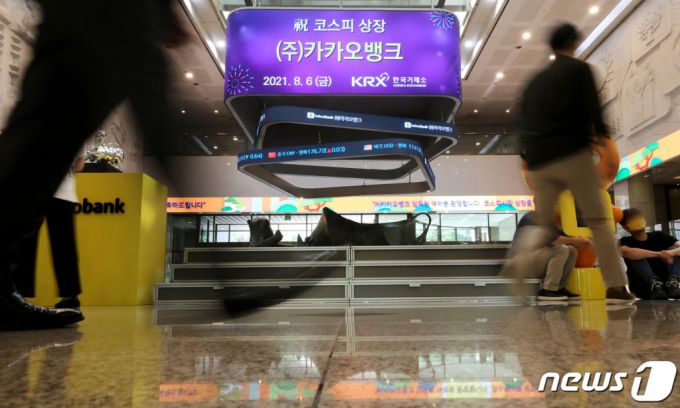 (서울=뉴스1) 이동해 기자 = 카카오뱅크가 상장 첫날 KB금융을 제치고 금융대장주(株)에 등극했다. 시초가가 공모가의 2배를 형성하지는 못했지만 외국인 매수세가 강하게 유입되면서 주가는 20%대 상승률을 유지하고 있다. 6일 오전 서울 영등포구 여의도 한국거래소 전광판에 카카오뱅크의 코스피 상장을 알리고 있다. 2021.8.6/뉴스1