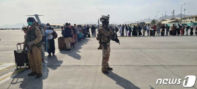 22일(현지시간) 탈레반이 장악한 아프가니스탄의 카불 공항에서 아프간 피난민들이 이탈리아 군용기를 타기 위해 기다리고 있다. /AFP=뉴스1