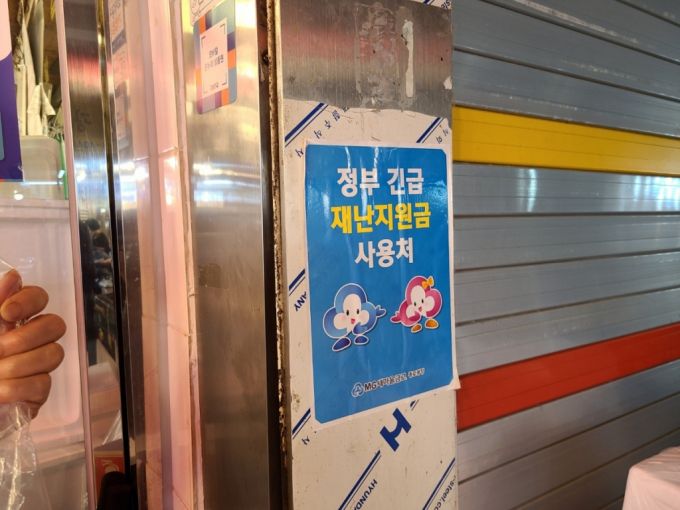 7일 오후 2시쯤 서울시 중구 광장시장의 한 정육점 벽면에 '재난지원금 사용처'임을 알리는 전단지가 붙어있다./사진=하수민 기자.