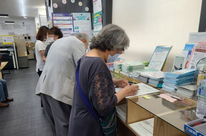13일 오전 9시 서울 중구 필동 주민센터 남모씨(77)가 코로나 상생 국민지원금 신청을 위해 서류를 작성하고 있다. /사진 = 하수민 기자