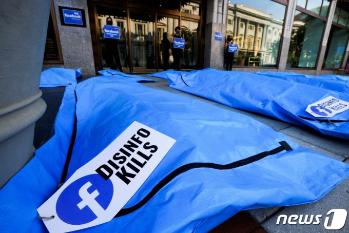 (워싱턴 로이터=뉴스1) 이정후 기자 = 28일(현지시간) 미국 워싱턴 페이스북 지사 앞에서 코로나19 허위 정보를 규제하지 않는 페이스북에 항의하기 위해 시위대가 시체 가방을 전시하고 있다.  (C) 로이터=뉴스1