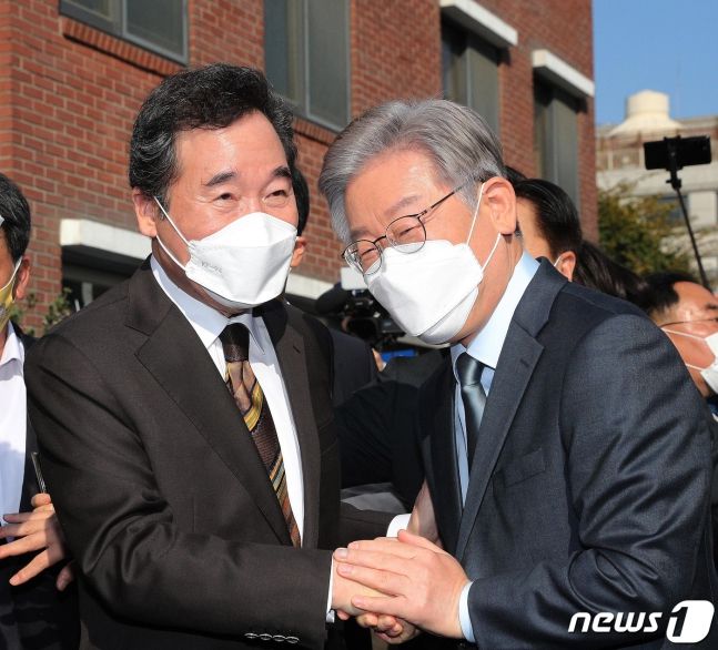 이재명 더불어민주당 대선 후보(오른쪽)와 이낙연 전 민주당 대표가 24일 오후 서울 종로구 안국동의 한 찻집 앞에서 회동 전 손을 맞잡고 있다. 2021.10.24/뉴스1 (C) News1 국회사진취재단