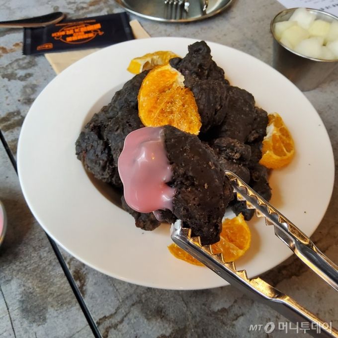 건강에 좋은 오징어 먹물 튀김 옷을 입히고 황금올리브 오일에 바삭하게 튀겨낸 '까먹(물)치킨'을 새콤달콤한 백년초 소스에 찍어보았다./사진=구단비 기자