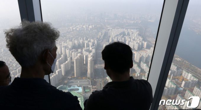 (서울=뉴스1) 박세연 기자 = 5일 서울 송파구 롯데월드 서울스카이 전망대를 찾은 관람객이 아파트단지가 밀집한 서울시내를 바라보고 있다.  서울 아파트 매매수급지수 하락세가 계속됐다. 동북권과 동남권을 제외한 모든 권역에서 하락세가 감지됐다. 이날 한국부동산원이 발표한 '11월 1주(1일 기준) 전국 주간 아파트 가격 동향'에 따르면 서울의 아파트 수급 동향은 100.7로 조사됐다. 아파트 수급 동향은 100을 기준으로 0에 가까울수록 공급우위, 100에 가까울수록 수요 우위를 뜻한다. 지난 4월 이후 꾸준히 100 이상을 웃돌다 9월 이후 지속적으로 하락하며 지난 주부터 100에 진입했다. 서울 아파트 시장에서 매수자 우위 전환이 임박했다는 해석이 나온다.  동북권과 동남권을 제외한 나머지 권역에서 하락세가 지속하면서 100에 근접한 수치를 보였다. 가장 낮은 곳은 서북권이다. 서북권은 99.8로 서울 권역 중 유일하게 매수자 우위로 전환됐다. 그 뒤를 Δ동남권(100.5) Δ서남권·강남권(100.6) Δ도심권(100.7) Δ강북권(100.9) 등이 따랐다. 동북권은 101.3으로 권역 중 가장 높았다. 2021.11.5/뉴스1