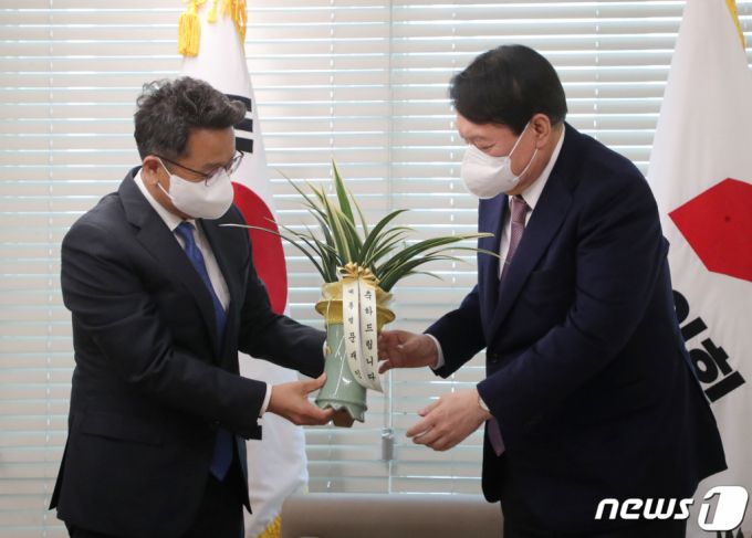 (서울=뉴스1) 구윤성 기자 = 윤석열 국민의힘 대선 후보가 15일 서울 여의도 중앙당사에서 이철희 청와대 정무수석으로부터 문재인 대통령의 축하 난을 전달받고 있다. 2021.11.15/뉴스1