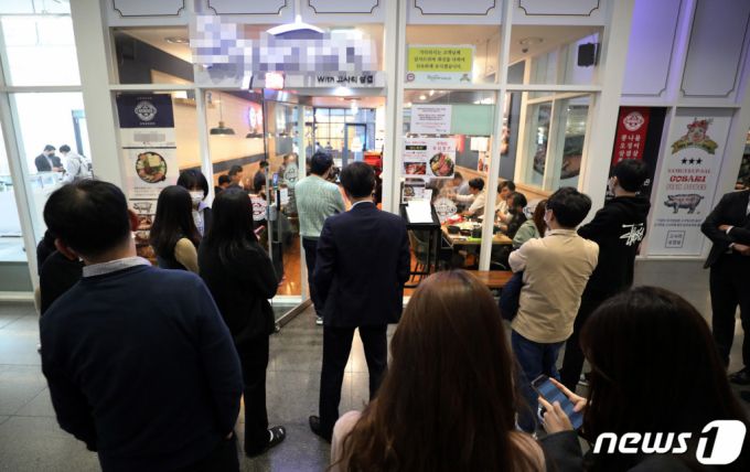 (서울=뉴스1) 박세연 기자 = 3일 점심시간 서울시내 식당가에서 시민들이 식사를 하기위해 대기하고 있다.   지난1일부터 위드코로나를 위한 단계적 일상회복이 시작됐다. 이제 가족이나 지인들과 수도권 10명, 비수도권 12명까지 모일 수 있다, 식당과 카페 등 대부분 시설의 영업시간 제한도 사라졌다. 그래도 마스크는 계속 착용해야한다. 방역수칙이 완화되고 재택근무도 사라지며 점심 식당가와 번화가는 모처럼 활기를 띠고 있다. 2021.11.3/뉴스1