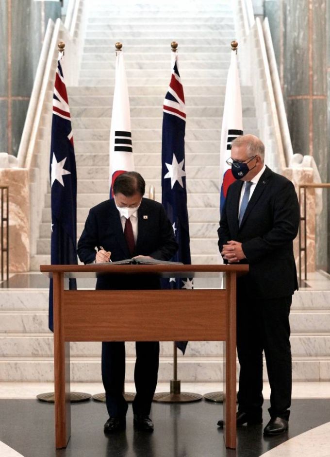 [캔버라=뉴시스] 전진환 기자 = 호주를 국빈 방문 중인 문재인 대통령이 스콧 모리슨 호주 총리와 정상 회담 등을 위해 13일 오전 캔버라 국회의사당에 도착, 방명록을 작성하고 있다. 오른쪽은 스콧 모리슨 호주 총리. 2021.12.13.