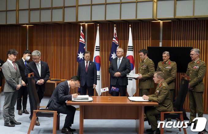 (서울=뉴스1) = 호주를 국빈 방문 중인 문재인 대통령이 13일 캔버라 국회의사당에서 열린 한화 디펜스와 호주 국방부 획득관리단의 호주 육군 K-9 자주포 획득사업 계약 서명을 스콧 모리슨 총리와 함께 바라보고 있다.(청와대 제공) 2021.12.13/뉴스1