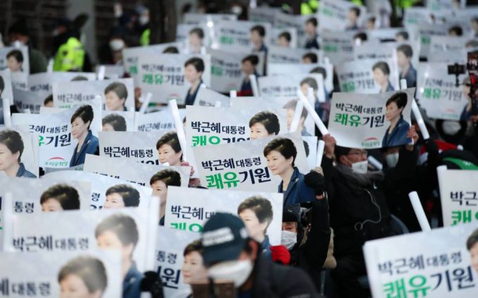 [서울=뉴시스] 고범준 기자 = 24일 오후 서울 강남구 삼성서울병원 앞에서 열린 박근혜 전 대통령 석방 축하 및 건강 기원 집회(제215차 태극기집회)에서 지지자들이 박 전 대통령 얼굴이 그려진 손 피켓을 들고 있다. 2021.12.24.