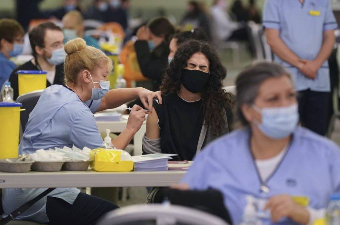 [글래스고=AP/뉴시스] 29일(현지시간) 스코틀랜드 글래스고의 햄든 파크 코로나19 백신 접종소에서 한 여성이 부스터 샷을 맞으며 얼굴을 찌푸리고 있다. 영국은 코로나19 일일 확진자 수가 18만3037명 발생해 전날의 12만9471명보다 약 5만 명이 늘어 역대 최대치를 하루 만에 갈아치웠다. 2021.12.30.