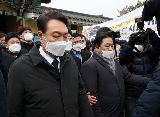 윤석열 국민의힘 대선후보(왼쪽)가 6일 오후 광주 국립5·18민주묘지를 찾아 참배한 뒤 시민단체의 항의를 받으며 발길을 돌리고 있다. 윤 후보는 이날 참배를 반대하는 '5월어머니들' 등 시민단체 항의에 막혀 추모탑 입구에서 묵념으로 참배를 대신했다. 2022.2.6/뉴스1