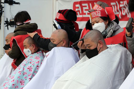 (서울=뉴스1) 황기선 기자 = 코로나19피해자영업총연합(코자총) 회원들이 15일 오후 서울 종로구 광화문 시민열린마당에서 열린 '정부 규탄 광화문 총집회'에서 삭발식을 진행하고 있다. 이날 회원들은 총집회를 통해 정부의 방역지침에 맞서 오는 21일부터 24시간 영업에 나서겠다고 밝혔다. 2022.2.15/뉴스1