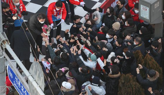 (서울=뉴스1) 국회사진취재단 = 윤석열 국민의힘 대선 후보가 17일 오후 서울 송파구 석촌호수에서 열린 "경제를 살리는 대통령!" 송파 유세에서 지지자로부터 꽃다발을 받고 있다. 2022.2.17/뉴스1