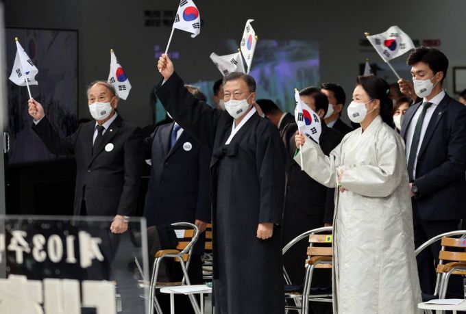 [서울=뉴시스] 김진아 기자 = 문재인 대통령과 김정숙 여사가 1일 서울 서대문구 국립 대한민국임시정부 기념관에서 열린 제103주년 3.1절 기념식에서 참석자들과 만세삼창을 마친 뒤 태극기를 흔들고 있다. 2022.03.01.