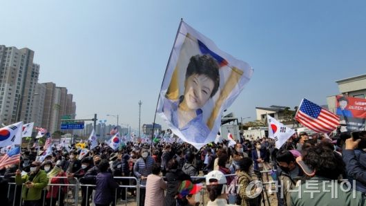 24일 오후 12시30분. 박근혜 전 대통령이 대구 달성군 사저에 들어간 직후 지지자들이 태극기와 박 전 대통령의 사진을 흔들고 있는 모습./사진=김도균 기자