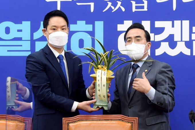 박홍근(오른쪽) 더불어민주당 신임 원내대표가 25일 오전 서울 여의도 국회에서 김한규 대통령비서실 정무비서관에게 문재인 대통령의 축하 난을 받고 감사 인사를 전하고 있다. (공동취재사진) 2022.03.25.