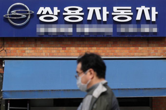 [서울=뉴시스] 백동현 기자 = 에디슨모터스의 쌍용차 인수계약이 무산될 위기에 놓인 27일 오전 서울 시내 한 쌍용차 판매점 앞에서 시민이 이동하고 있다. 이날 법조계에 따르면 에디슨모터스 컨소시엄은 인수대금 잔금 납입 기한인 지난 25일까지 잔금을 지급하지 못했다고 밝혔다. 2022.03.27.