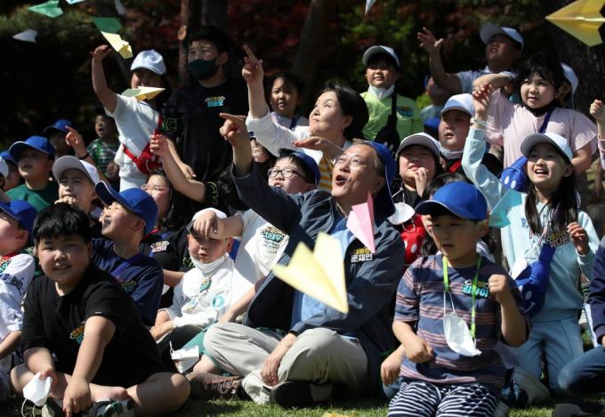 [서울=뉴시스] 전신 기자 = 문재인 대통령이 5일 청와대 녹지원에서 열린 2022년 어린이날 100주년 기념 청와대 어린이 초청행사에서 아이들과 종이비행기를 날리며 기념촬영하고 있다. 2022.05.05.