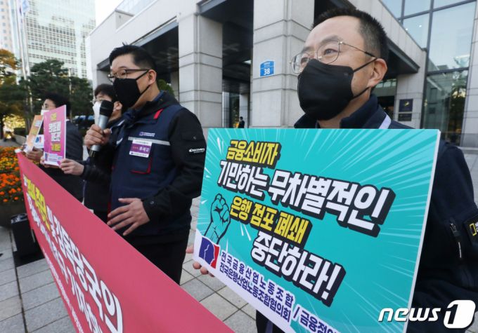 (서울=뉴스1) 송원영 기자 =  25일 서울 영등포구 금융감독원 앞에서 전국은행산업노동조합협의회 회원들이 '은행 점포폐쇄 중단 및 감독당국의 점포폐쇄 절차 개선 촉구' 기자회견을 하고 있다. 이날 기자회견에서 참석자들은 "실적 경쟁하 듯 점포 폐쇄 이어가는 은행에 금융당국의 브레이크가 필요하다"고 밝혔다. 2021.10.25/뉴스1