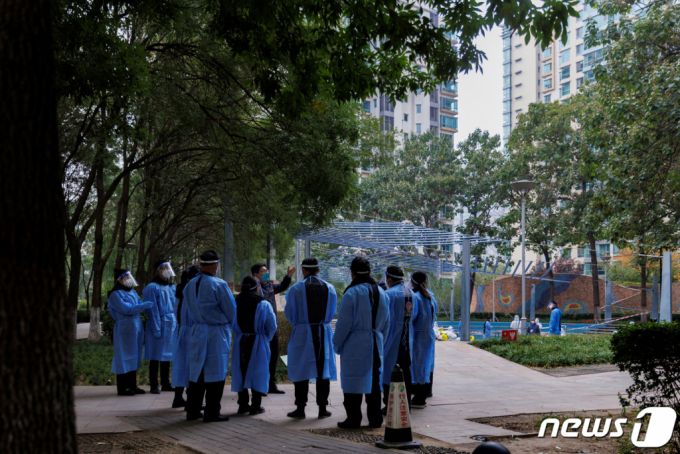 (베이징 로이터=뉴스1) 한병찬 기자 = 20일(현지시간) 중국 베이징에서 보호복을 입은 의료진과 경비원이 코로나바이러스 감염증(코로나19) 발생으로 폐쇄된 주거 단지에 서 있다.  ⓒ 로이터=뉴스1  Copyright (C) 뉴스1. All rights reserved. 무단 전재 및 재배포 금지.