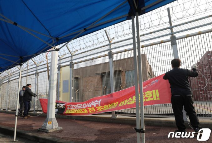 (평택=뉴스1) 김영운 기자 = 민주노총 공공운수노조 화물연대본부의 집단운송거부(총파업) 16일째를 끝으로 파업 종료를 결정한 9일 오후 경기 평택시 포승읍 평택항 인근에 설치된 현수막을 화물연대 조합원들이 철거하고 있다.  화물연대는 이날 총파업 철회 여부를 결정하기 위한 총투표를 진행했으며 투표 결과는 파업 종료로 가결됐다. 2022.12.9/뉴스1  Copyright (C) 뉴스1. All rights reserved. 무단 전재 및 재배포 금지.