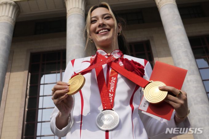 2022 베이징 동계올림픽 메달리스트 에일린 구(중국명 구아이링)가 지난 4월 중국 베이징 인민대회당에서 열린 베이징 동계올림픽·패럴림픽 총결 표창식 참석 전 자신이 딴 메달 3개를 들고 포즈를 취하고 있다. /AP=뉴시스