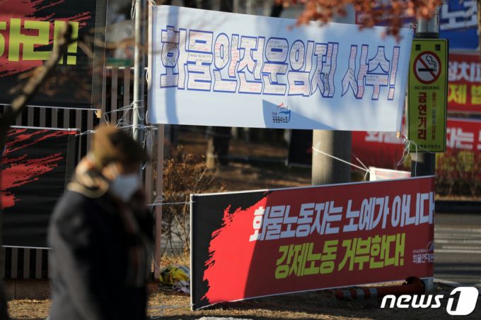 (서울=뉴스1) 이승배 기자 = 공정거래위원회(공정위)가 현장조사를 거부한 민주노총 공공운수노조 화물연대본부(화물연대)에 대한 고발 여부를 10일 심의할 예정이다. 앞서 공정위는 화물연대가 총파업 과정에서 소속 사업자에게 파업 동참(운송 거부)을 강요하거나 다른 사업자의 운송을 방해했는지 등을 조사하기 위해 지난해 12월 세 차례에 걸쳐 현장 조사를 시도했으나 화물연대 측이 건물 진입을 거부함에 따라 무산된 바 있다.  이날 서울 여의도 국회 앞 화물연대 농성장 인근에 화물안전운임제 사수 현수막이 걸려있다. 2023.1.10/뉴스1  Copyright (C) 뉴스1. All rights reserved. 무단 전재 및 재배포 금지.