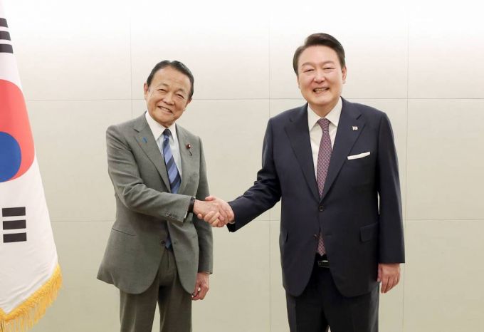 [도쿄=뉴시스 전신 기자 = 윤석열 대통령이 17일 도쿄 시내 한 호텔에서 열린 일한협력위원회 접견에서 일본 자민당 부총재인 아소 다로 전 총리와 악수하고 있다. 2023.03.17.