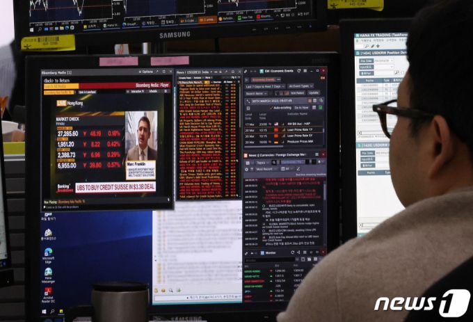 (서울=뉴스1) 구윤성 기자 = 20일 오전 서울 중구 하나은행 명동점 딜링룸에서 직원이 UBS의 크레디트스위스(CS) 인수 관련 뉴스를 살피고 있다. 스위스 최대 금융기관 UBS는 미국 실리콘밸리은행(SVB) 파산 여파로 위기에 빠진 세계적 투자은행 CS를 32억 달러에 인수했다. 2023.3.20/뉴스1  Copyright (C) 뉴스1. All rights reserved. 무단 전재 및 재배포 금지.