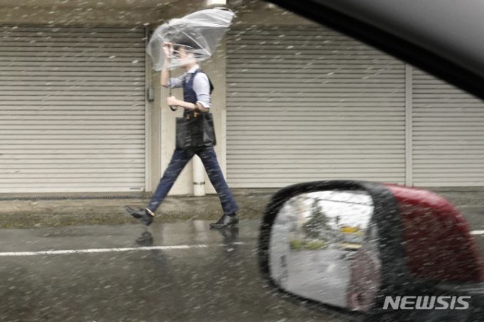[도쿄=AP/뉴시스] 제2호 태풍 마와르가 일본 도쿄 해상으로 접근하면서 2일 한 도쿄 시민이 우산으로 거친 비바람을 막으며 힘겹게 길을 가고 있다. 2023.06.02.