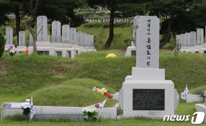 (대전=뉴스1) 김기태 기자 = 정부가 육군사관학교 교내뿐 아니라 국방부 청사 앞에 설치된 고(故) 홍범도 장군 흉상에 대해 이전을 검토 중인 것으로 알려진 가운데 28일 대전 유성구 국립대전현충원 애국지사묘역에서 홍범도 장군 묘역에 태극기가 놓여있다. 2023.8.28/뉴스1  Copyright (C) 뉴스1. All rights reserved. 무단 전재 및 재배포 금지.