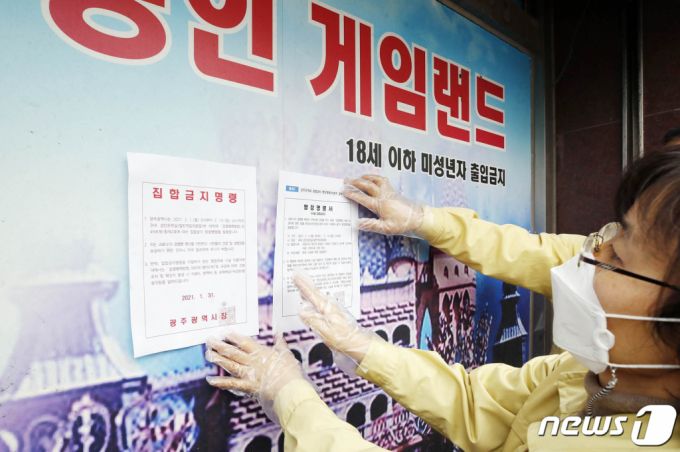 광주시가 성인오락실 156개소를 대상으로 집합금지 행정명령을 내린 2021년 2월 1일 광주 북구 공무원들이 북구 한 성인오락실에 집합금지 명령서를 붙이고 있다. /사진=뉴스1
