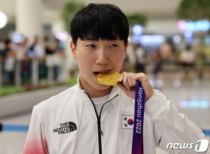 항저우 아시안게임 e스포츠 ‘스트리트 파이터 5’에서 금메달을 획득한 김관우가 지난달 29일 오후 인천국제공항 제2터미널을 통해 귀국한 뒤 기념 촬영을 하고 있다. /사진=뉴스1