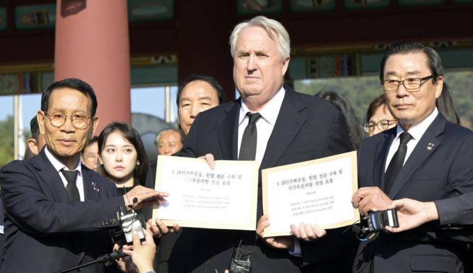 [광주=뉴시스] 변재훈 기자 = 인요한 국민의힘 혁신위원장이 30일 광주 북구 운정동 국립 5·18민주화묘지 앞에서 5·18공법단체 측 '오월정신 헌법 전문 수록·국가유공자법 개선' 건의 서한을 건네 받고 있다. 인 위원장은 항쟁 당시 시민군 통역을 맡은 바 있으며, 이날 참배는 국민의힘 혁신위 출범 첫 일정이다.  2023.10.30.