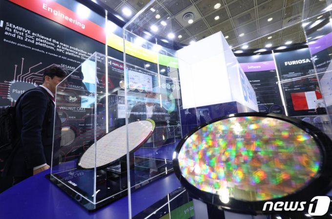 지난 10월25일 서울 강남구 코엑스에서 열린 반도체대전에서 관람객들이 반도체웨이퍼를 살펴보고 있다.  이번 행사에는 삼성전자와 SK하이닉스 등 국내 주요 반도체 기업들과 시스템 반도체 기업 및 소재·부품·장비 업체들이 참여했다. /사진=뉴스1.
