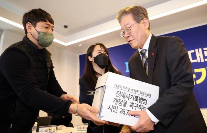 [부산=뉴시스] 하경민 기자 = 이재명 더불어민주당 대표가 13일 부산 수영구의 한 카페에서 전세사기 피해자들로부터 전세사기특별법 개정을 촉구하는 서명지를 전달받고 있다. 2023.12.13.