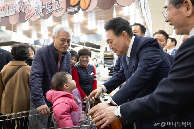 [서울=뉴시스] 윤석열 대통령이 18일 서울 서초구 농협하나로마트 양재점에서 물가 현장 점검을 하던 중 쇼핑카트에 탄 어린이에게 인사하고 있다. (사진=대통령실 제공) 2024.03.18. photo@newsis.com *재판매 및 DB 금지 /사진=조수정