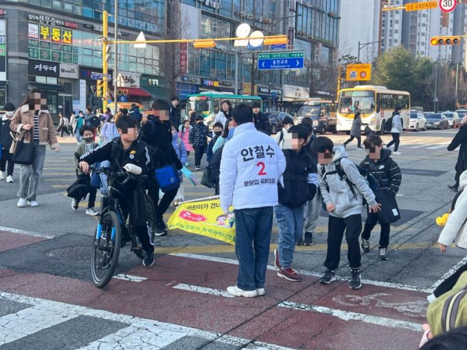 안철수 국민의힘 의원이 20일 오전 성남송현초등학교 사거리에서 교통봉사 중 마주친 학생들과 애화를 나누고 있다. /사진=박소연 기자