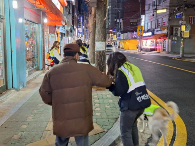 지난 21일 한 시민이 반려견 순찰대원을 보고 "수고가 많다"며 사탕을 건네는 모습. /사진=김지은 기자