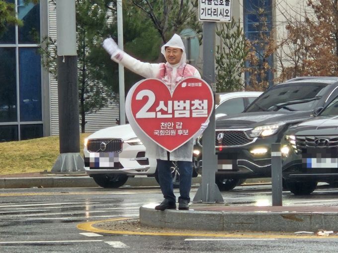 신범철 국민의힘 후보가 충남 천안시 청룡동의 한 사거리에서 퇴근하는 시민들을 향해 인사하고 있다/사진=안재용 기자