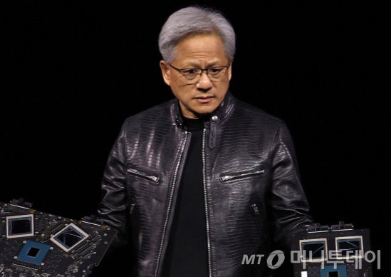 (새너제이 AFP=뉴스1) 김성식 기자 = 젠슨 황 엔비디아 최고경영자(CEO)가 18일(현지시간) 미국 캘리포니아 새너제이에서 진행된 엔비디아 주최 연례 개발자 회의 'GTC 2024'에서 생성형 인공지능(AI) 모델을 겨냥한 차세대 그래픽처리장치(GPU) 블랙웰(제품명 B200)을 공개하고 있다. 2024.3.18.  ⓒ AFP=뉴스1  Copyright (C) 뉴스1. All rights reserved. 무단 전재 및 재배포,  AI학습 이용 금지. /사진=(새너제이 AFP=뉴스1) 김성식 기자