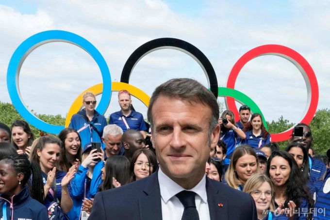 (파리 AFP=뉴스1) 권진영 기자 = 22일(현지시간) 프랑스 북부 생드니의 올림픽 선수촌을 방문한 에마뉘엘 마크롱 대통령이 오륜기를 배경으로 선수들과 기념 사진을 찍고 있다. 2024.07.22/  ⓒ AFP=뉴스1  Copyright (C) 뉴스1. All rights reserved. 무단 전재 및 재배포,  AI학습 이용 금지. /사진=(파리 AFP=뉴스1) 권진영 기자